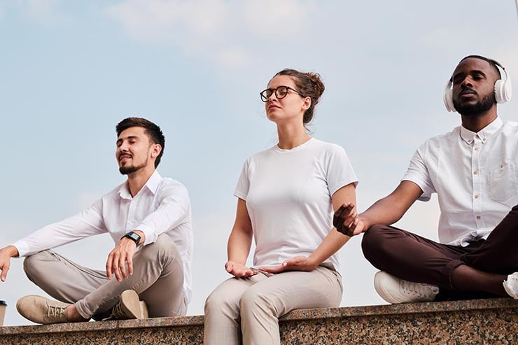 A group relaxing outdoors while doing meditation