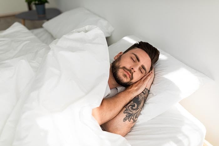 hombre joven en sueño profundo después de la meditación guiada para dormir