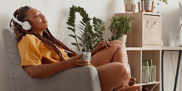 femme se relaxant à la maison en écoutant de la musique