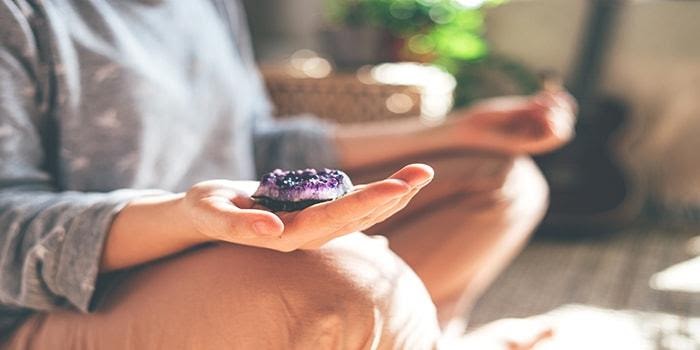 kvinna som använder sig av chakra meditation för att koppla av