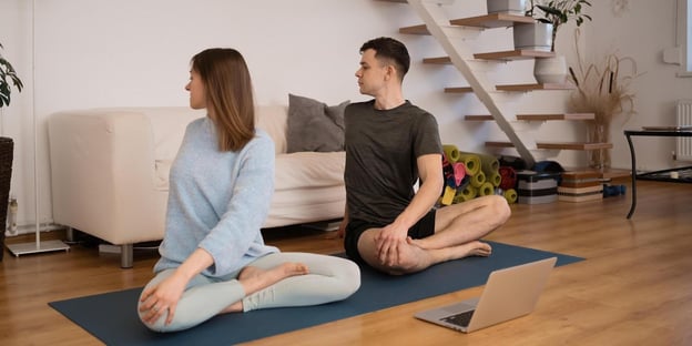 ett par som deltar i online yoga klasser tillsammans, i tryggheten från deras hem
