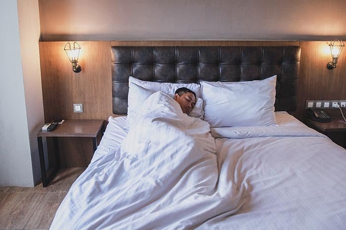 mężczyzna śpiący na swoim łóżku