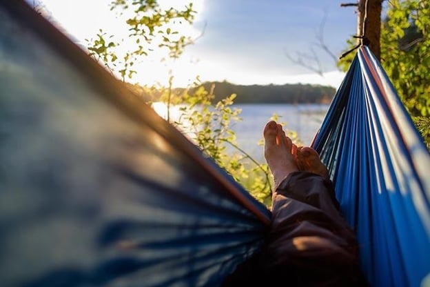 young man laying in a hammock performing stress management for teens