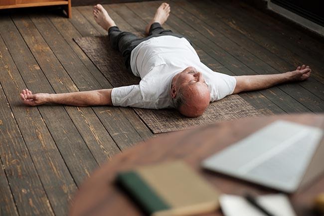 äldre man som tränar yoga nidra i hemmet, för att få sova bättre om natten