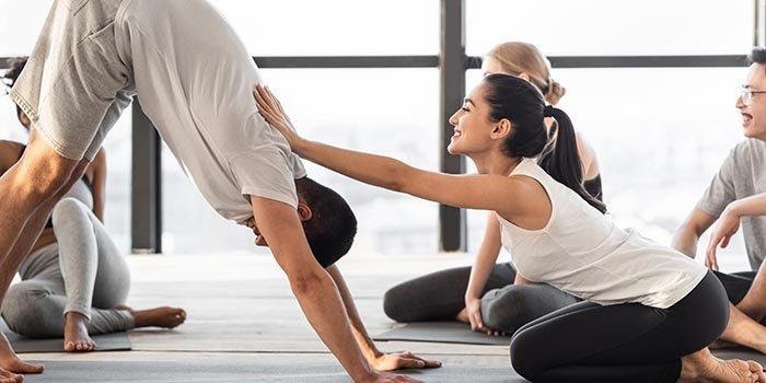 kvinnlig tränare som undervisar en gruppkurs i yoga för nybörjare