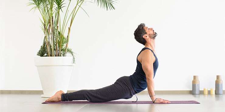 man doing urdhva mukha savasana indoors