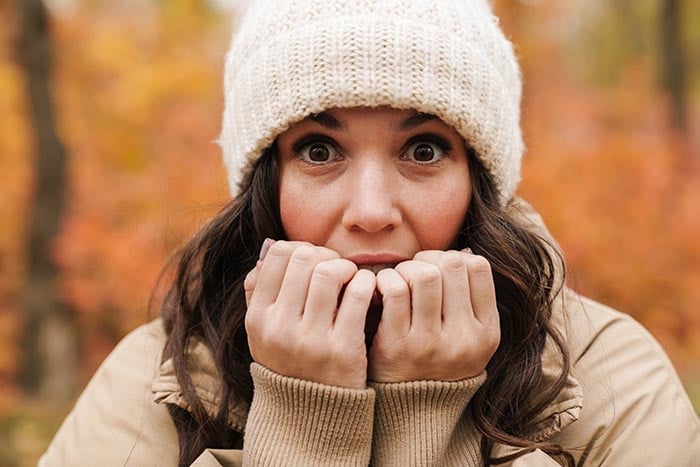 bella donna spaventata con cappello a maglia che contempla lotta o fuga