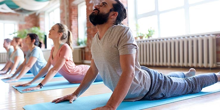 group doing cobra pose in hot yoga