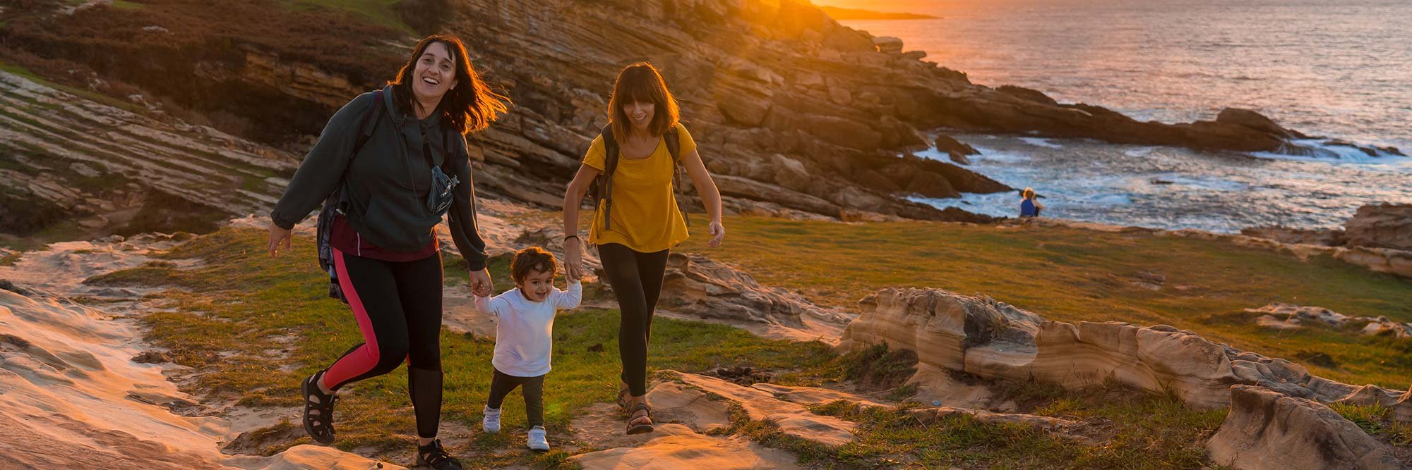 couple walking with their child along the shore enjoying a healthy lifestyle