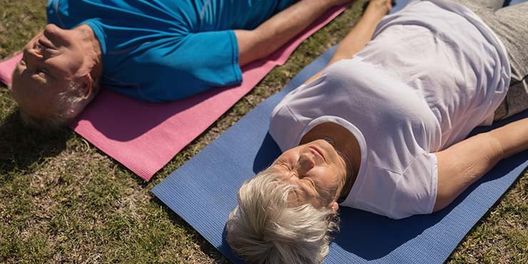 Pareja de ancianos practicando yoga nidra