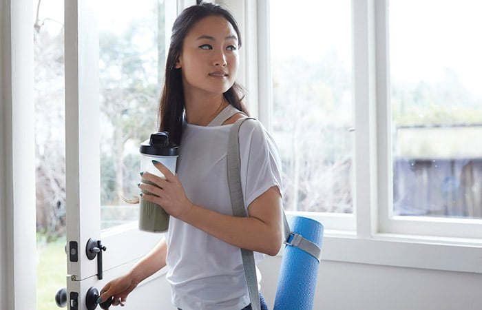 Healthy woman with yoga mat and a smoothie