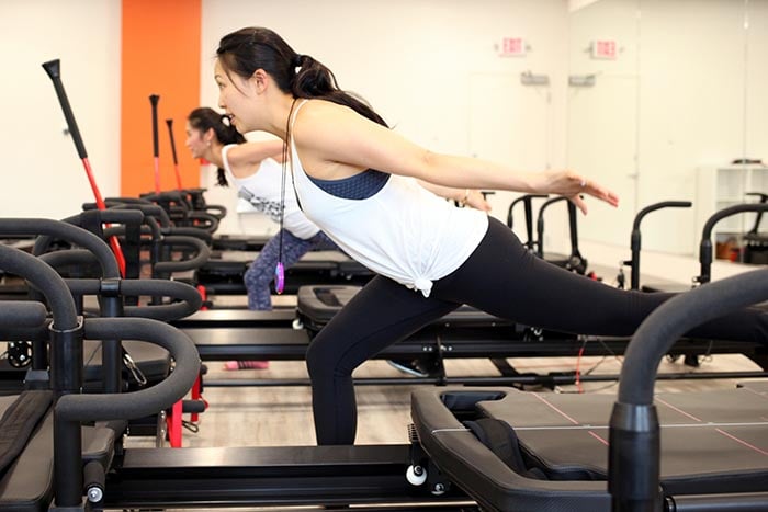 group-taking-part-in-group-pilates-class-700
