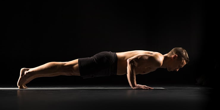 man performing chaturanga yoga pose