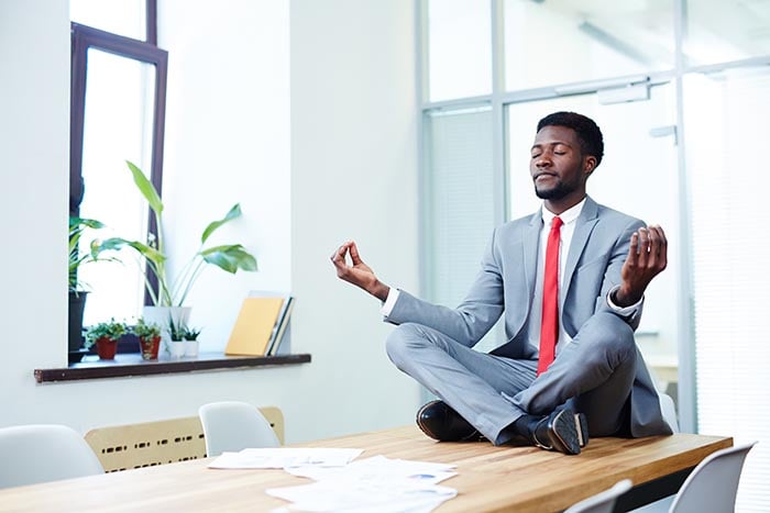 man performing corporate yoga as part of workplace wellness program