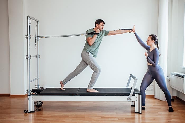 man doing pilates reformer exercise