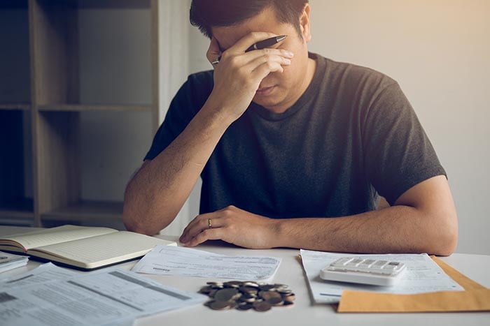 Mann, der wegen finanzieller Probleme gestresst ist, braucht ein Stressmanagement-System als Hilfe