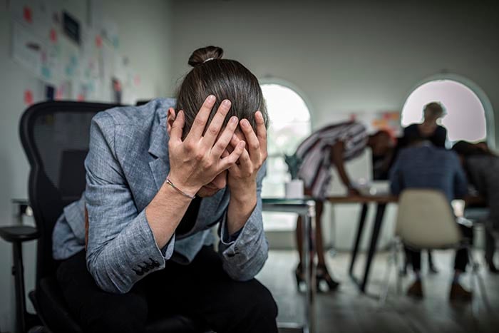 individual suffering from stress and anxiety in need of some stress management and workplace wellness program