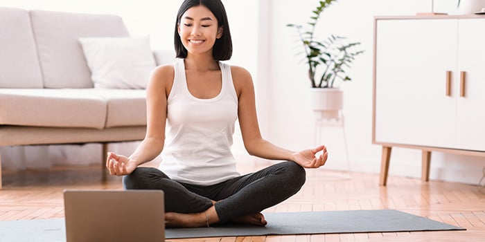 kvinna som arbetar med en onlinecoach för att meditera och förbättra sin psykiska hälsa