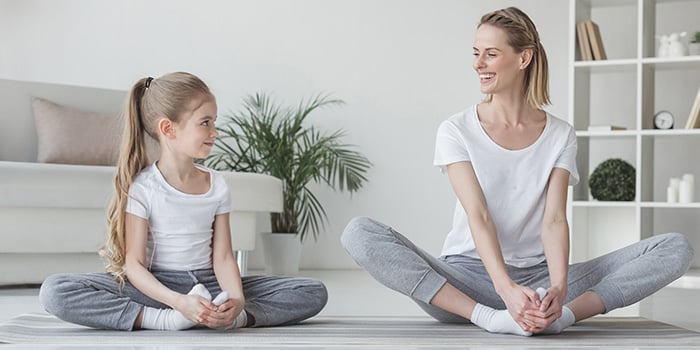 mother and daughter practicing butterfly pose in yin yoga together