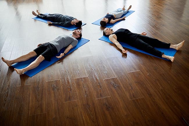 fyra personer som slappnar av samtidigt som de utövar yoga nidra tekniken