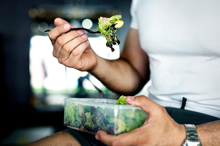 person enjoying mindful eating while eating a salad