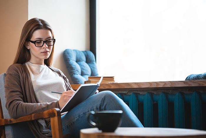 portrait of mindful female sitting reading a book