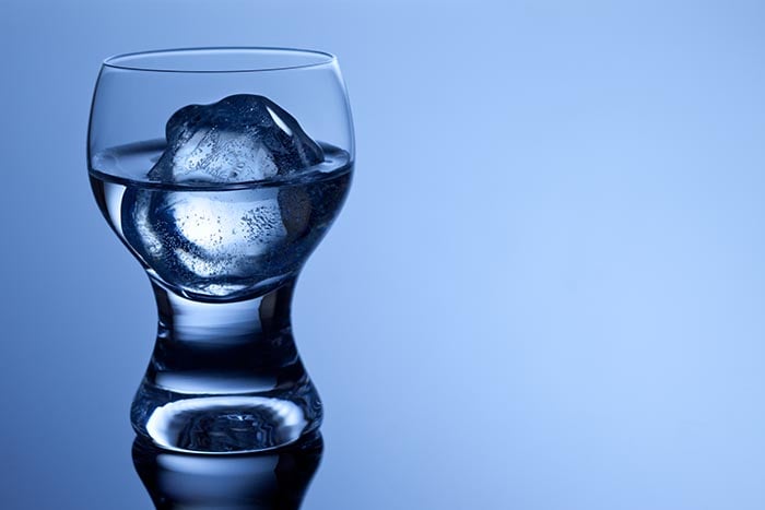 glass filled with water and a round ice cube
