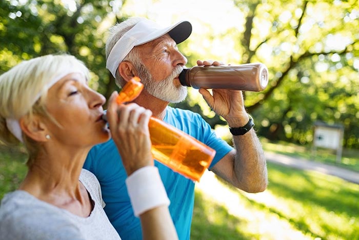 senior-couple-staying-hydrated-after-exercising-700