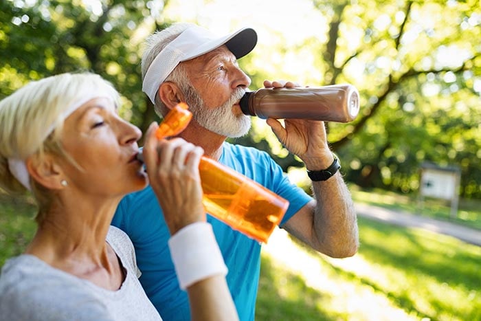 senior couple staying hydrated after exercising