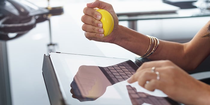 femme utilisant une balle anti-stress pour réduire le stress