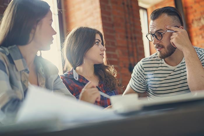 three persons communicating at the workplace