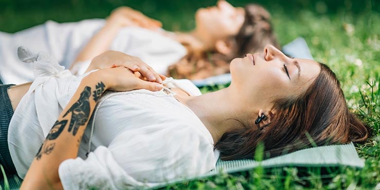 két nő tanulja a jóga nidrát az alváshoz