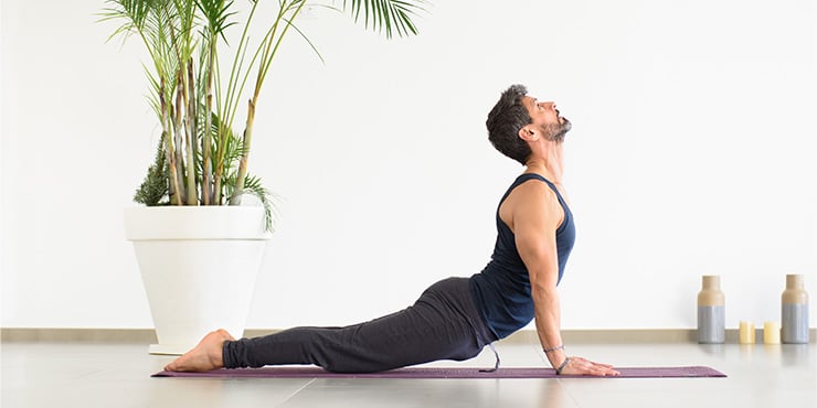 man doing urdhva mukha savasana indoors