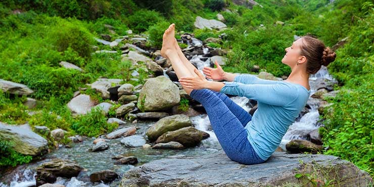 femme faisant la pose du bateau en ashtanga yoga
