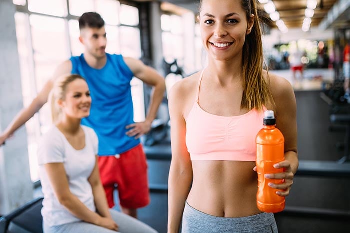 woman hydrating during workout drinking sport drink containing electrolytes