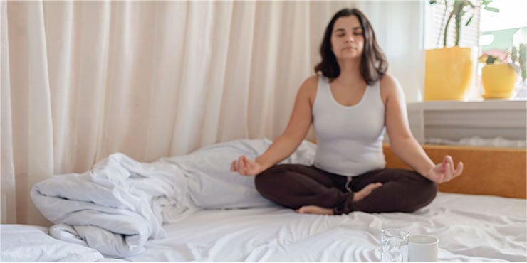 nő csinál alvás meditáció az ágyán