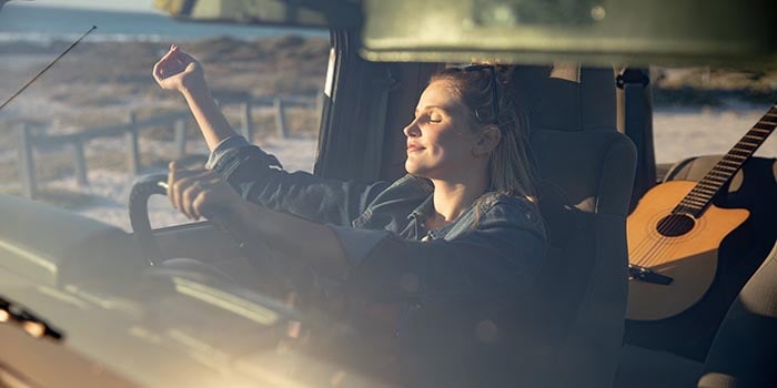 woman sitting in the car and relaxing in the sun