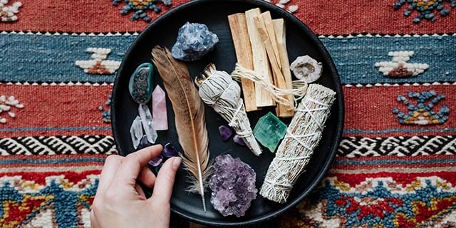 woman with sage and crystals ready for smudging