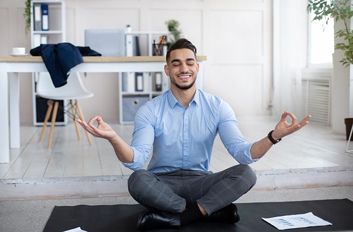 Stressmanagement am Arbeitsplatz Konzept ruhiger Mann, der Yoga praktiziert