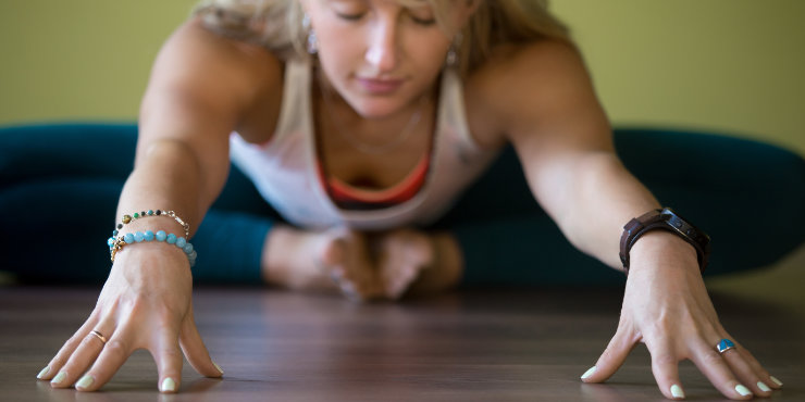 Mulher dobrando-se para a frente na pose de yin yoga borboleta