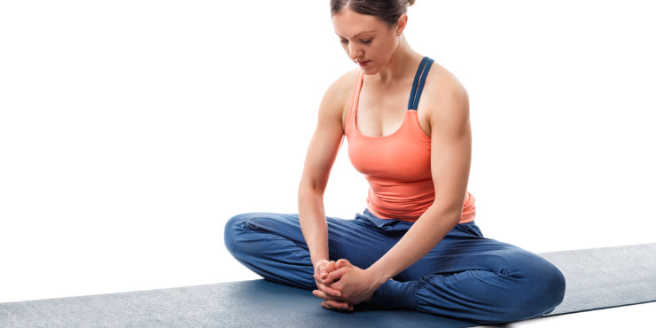Mujer sentada en posición erguida en postura de yin yoga mariposa