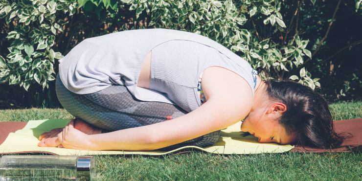 kvinna som gör yoga barnställning