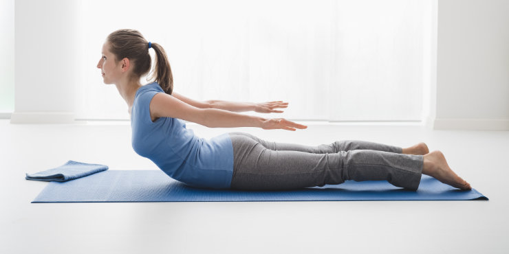 Frau in Yoga-Heuschrecken-Pose