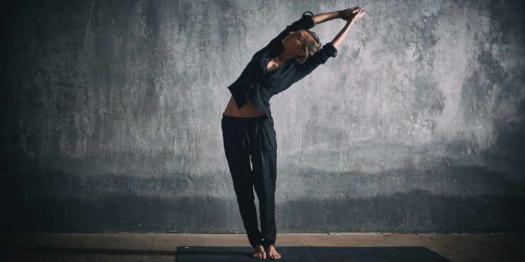 mujer en yoga de pie con inclinación lateral