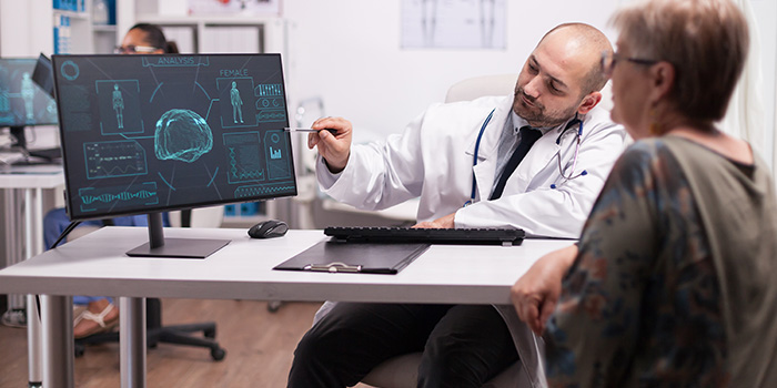 en doktor visar en bild på en hjärna tagen i en CT-scan