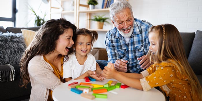 en morfar och mor som leker med sina barn och barnbarn som del av mindful föräldrarskap