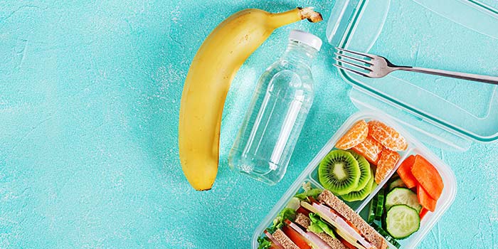 healthy habits school lunch box with sandwich vegetables water and a banana