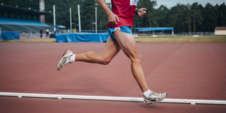 Corridore con ginocchia forti che corre.