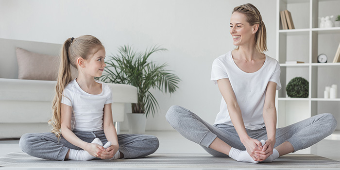 mor og datter øver sommerfugleposen i yin yoga sammen