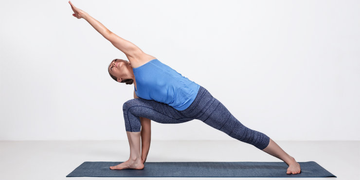 Femme faisant la pose de l'angle latéral en yoga